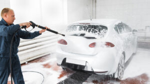 car-wash-employee-cleaning-dirt-pressure-water-foam
